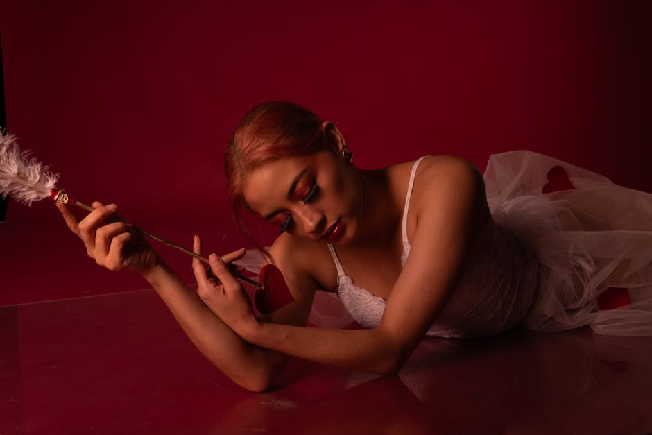 Woman performing a warrior pose with a serene expression, against a soft red background